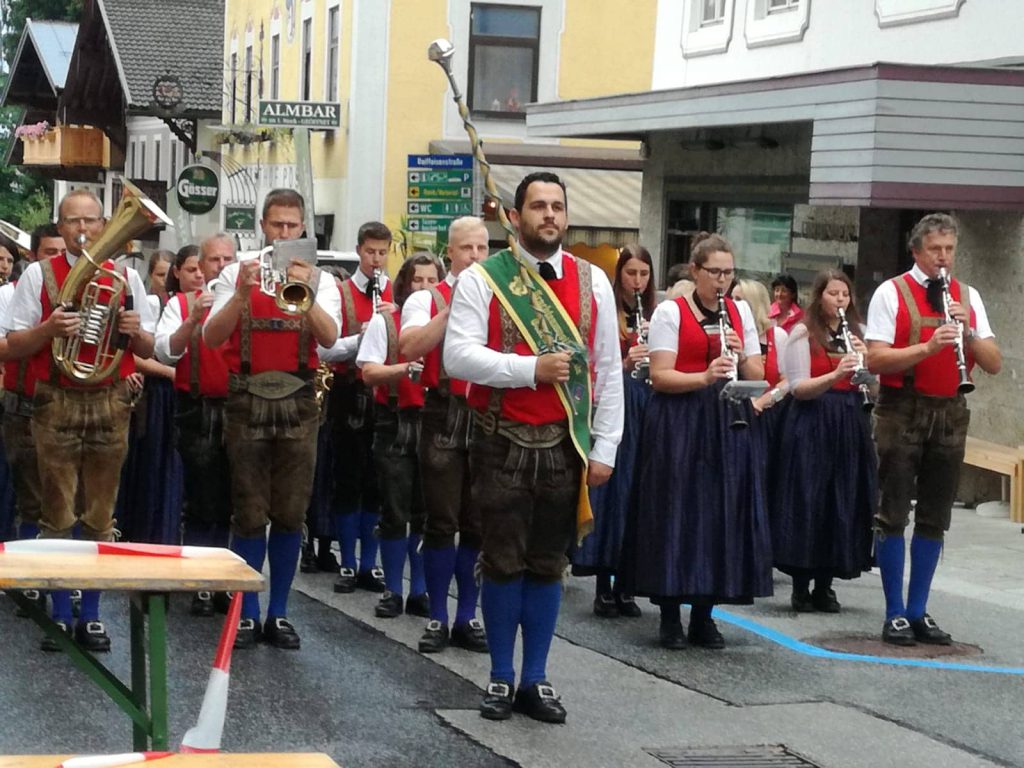 Trachtenmusikkapelle Taxenbach marschiert in traditioneller Tracht bei einem Konzert.