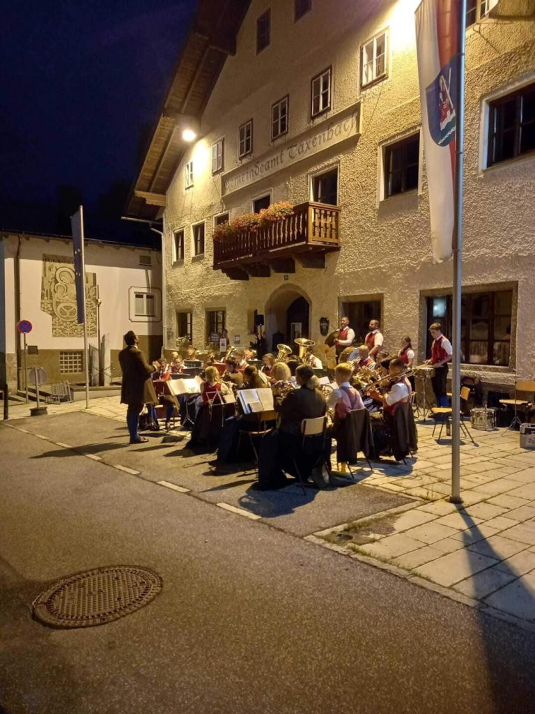 Trachtenmusikkapelle Taxenbach spielt bei einem Sommerkonzert in der Abendstimmung.